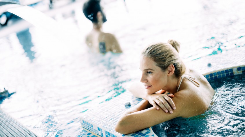 Portrait of beautiful woman relaxing in spa swimming pool